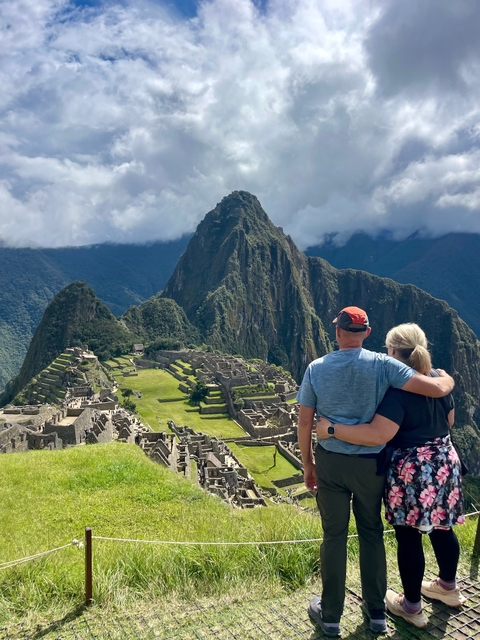 Two people embracing with a view of Machu Picchu in the background.