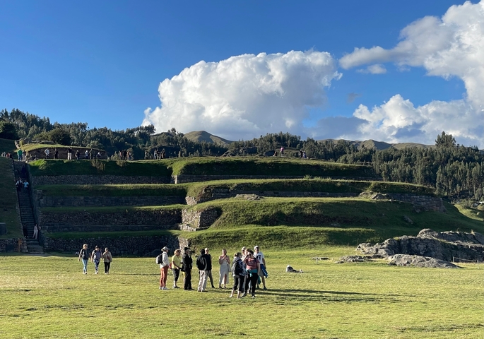       Group of people at a terrace with scenic landscape in the background.
  