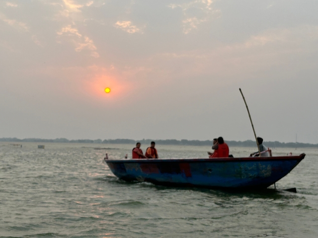 Silhouettes of people on a boat during sunset.