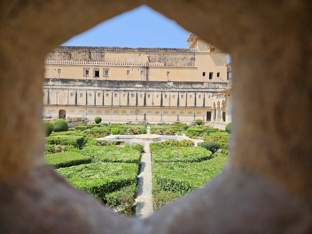       View of a garden through a decorative archway.
  