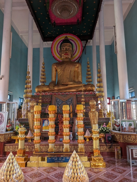 Ornate decorations and a golden statue inside a temple.