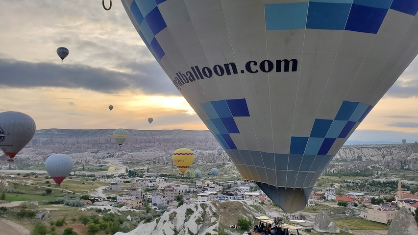 Hot air balloons over a rocky landscape at sunrise.