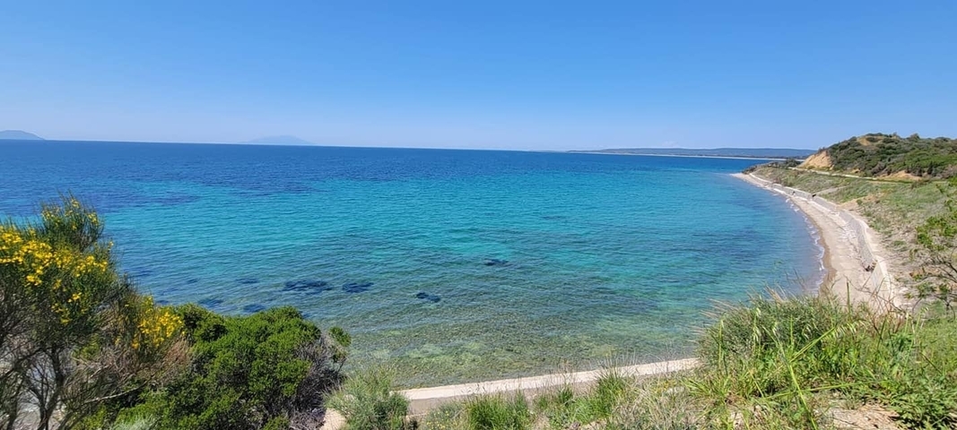       A clear, turquoise sea with a sandy beach.
  