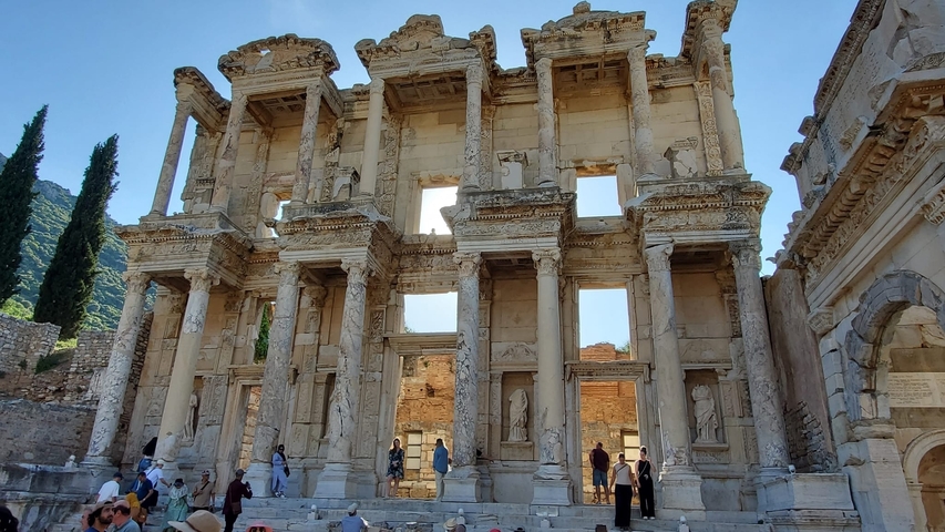       Famous ruins with tourists exploring the site.
  