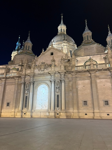       A large, ornate building facade at night.
  