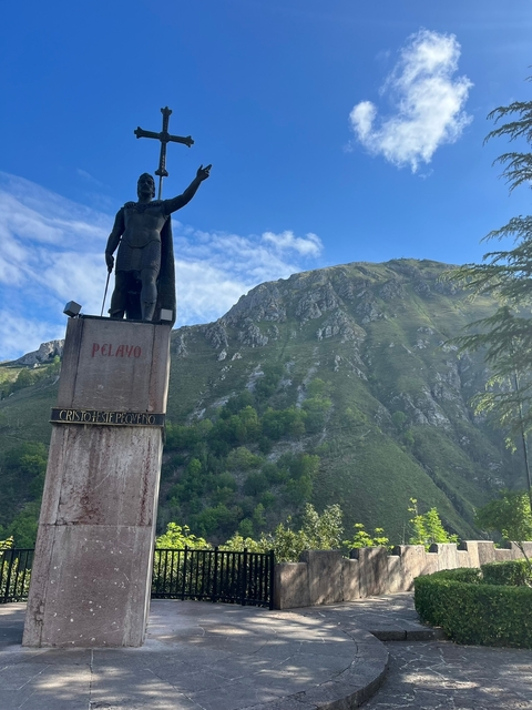       Statue with a mountain backdrop under a clear sky.
  