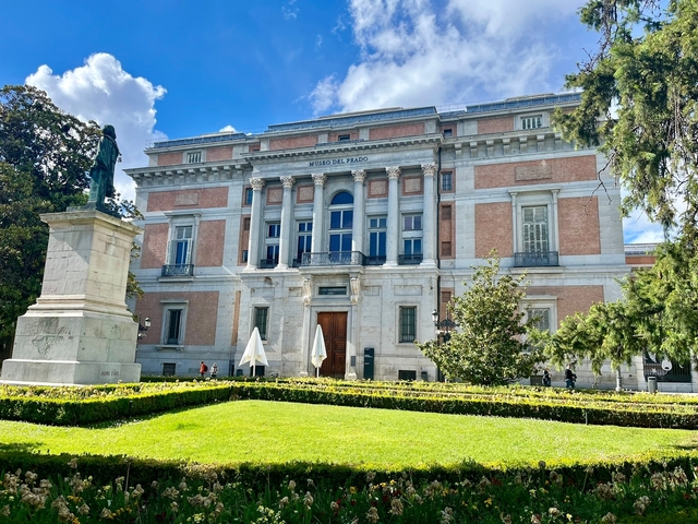       Classical building with columns and a manicured lawn.
  
