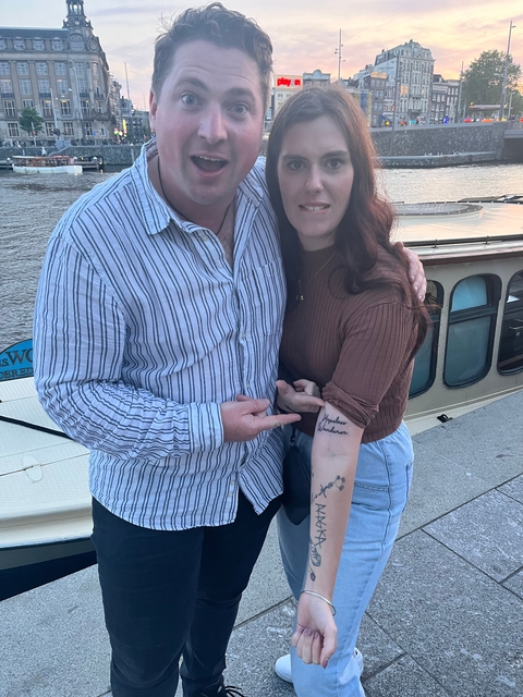 Two people by a riverboat.