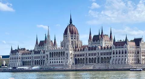 Elegant building with spires by a river.