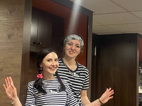 Two people in uniform posing indoors.
