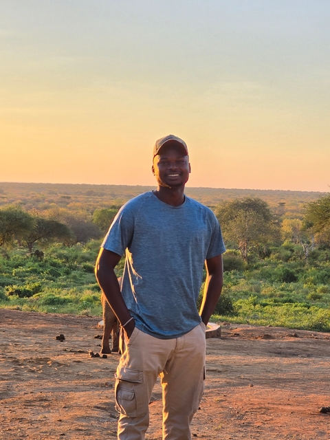       Person smiling with African landscape behind.
  