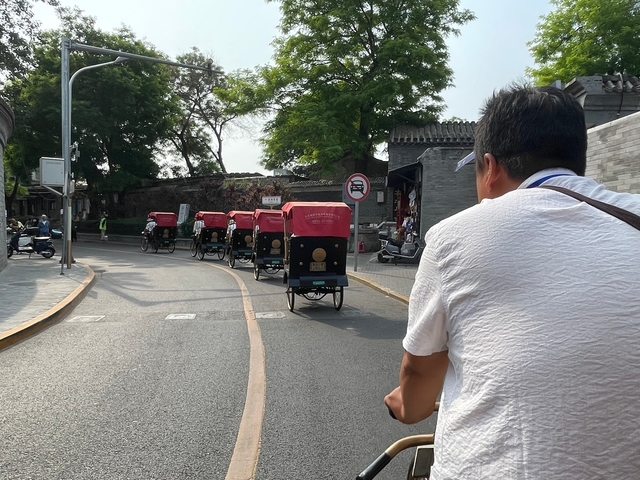 A person riding a rickshaw through a city street.