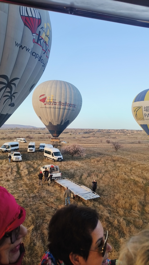 Hot air balloons preparing for takeoff over grassy fields