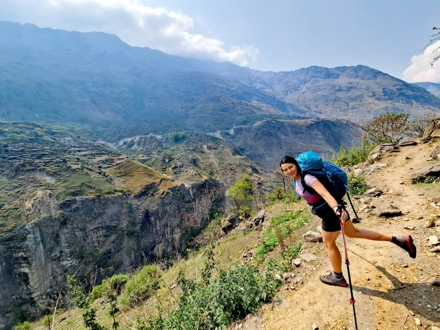       Smiling hiker posing on a mountain trail
  