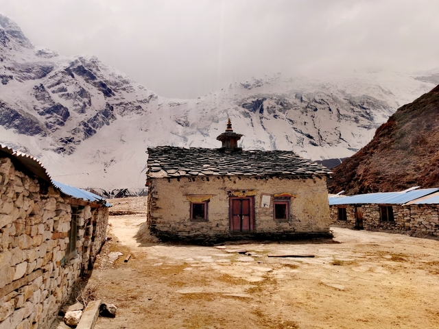       Traditional building with mountains in the background
  