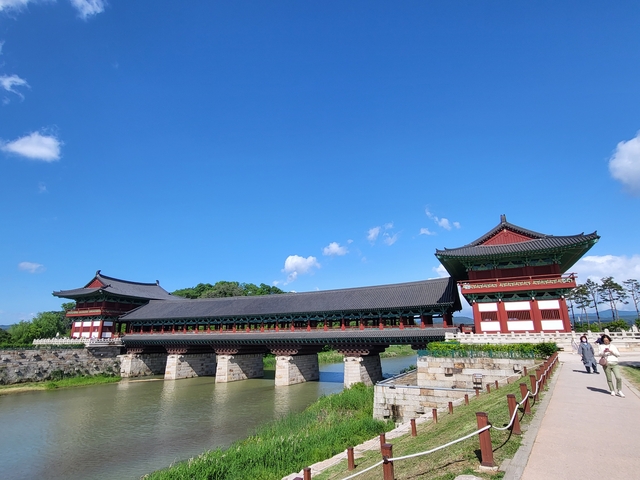 Traditional Korean palace building with a bridge over water.