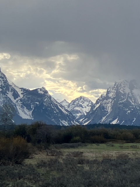       Snow-covered mountain peaks with a dramatic cloudy sky.
  