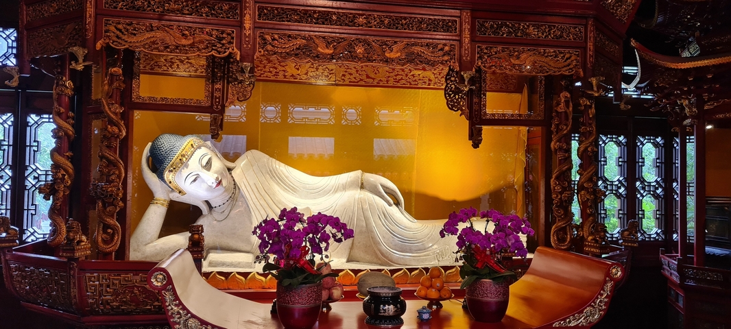       Reclining Buddha surrounded by decorative elements.
  