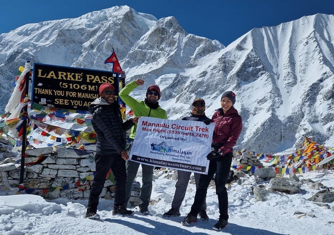       Group of trekkers at Larke Pass with mountains.
  