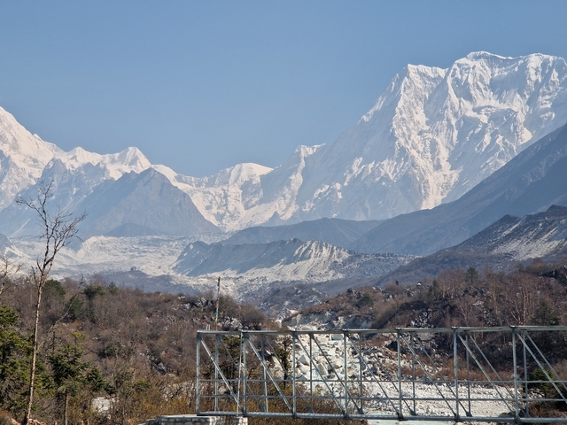       Vast mountain range with snow and clear blue sky.
  