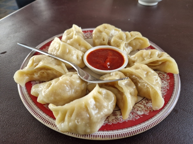       Plate of momo dumplings with sauce.
  