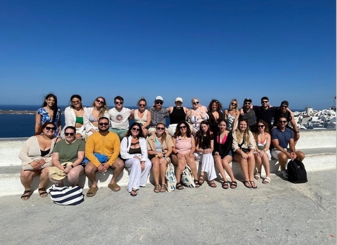 Large group photo with a coastal backdrop.