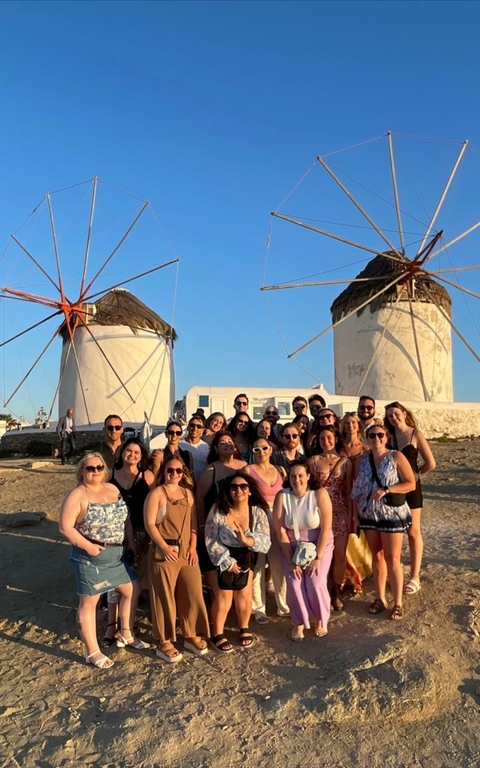 Group posing in front of traditional windmills.
