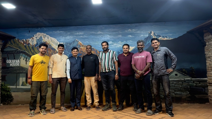 Group of people in front of a mountain mural.