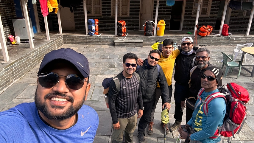 Group of people with backpacks posing happily.