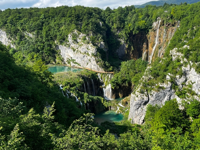       Scenic aerial view of cascading waterfalls and greenery.
  