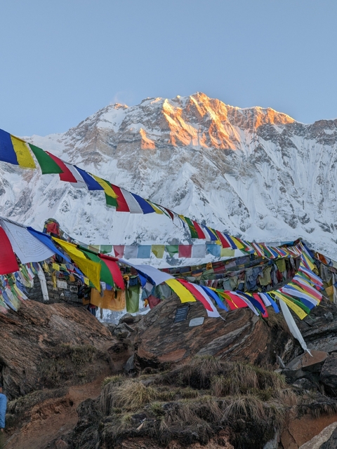       Colorful prayer flags with snow-capped mountains in the background.
  