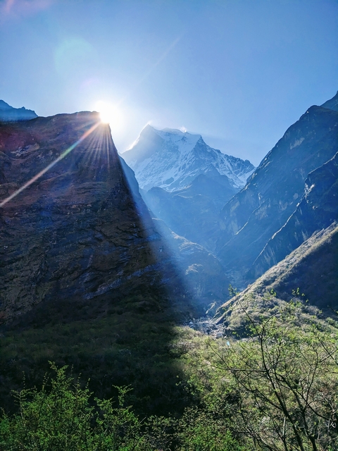       Sunlight streaming over mountain peaks.
  