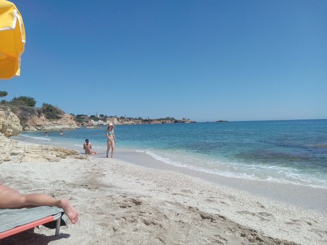       Beach scene with people enjoying the water and sand.
  