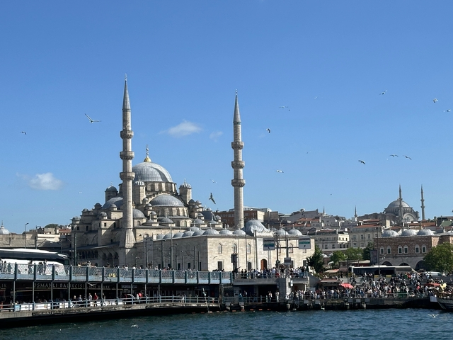       Iconic mosque with multiple minarets under a blue sky.
  