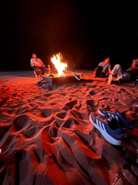 People sitting around a campfire at night.