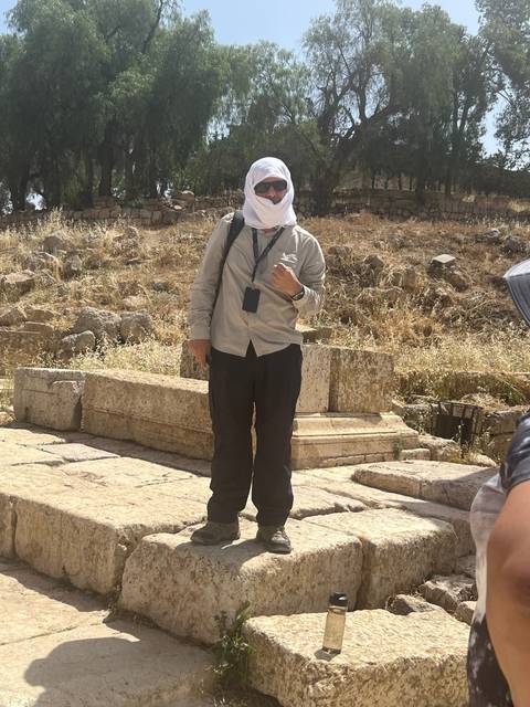 A person standing by ancient ruins.