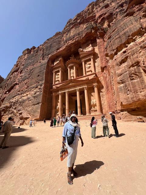       Visitors at the Petra archaeological site with the Treasury in the background.
  