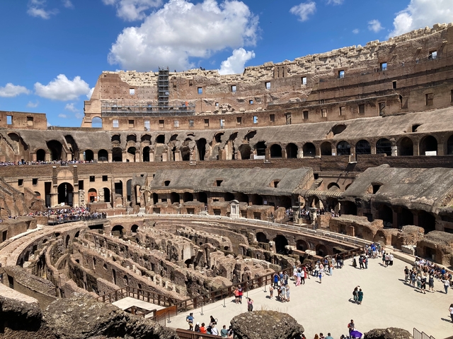 Inside view of the Colosseum with tourists walking around.