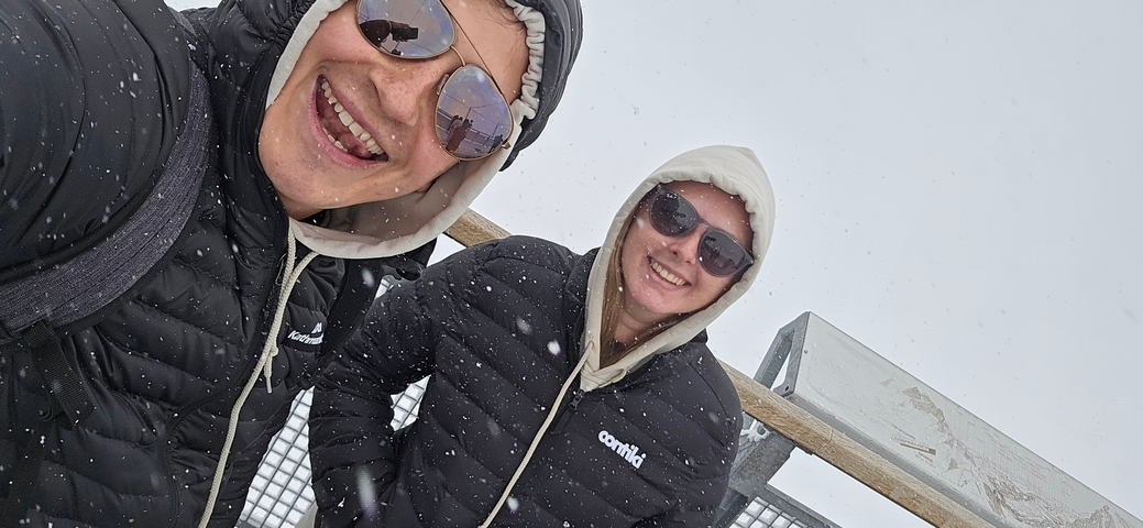 Two people taking a selfie in a snowy environment.