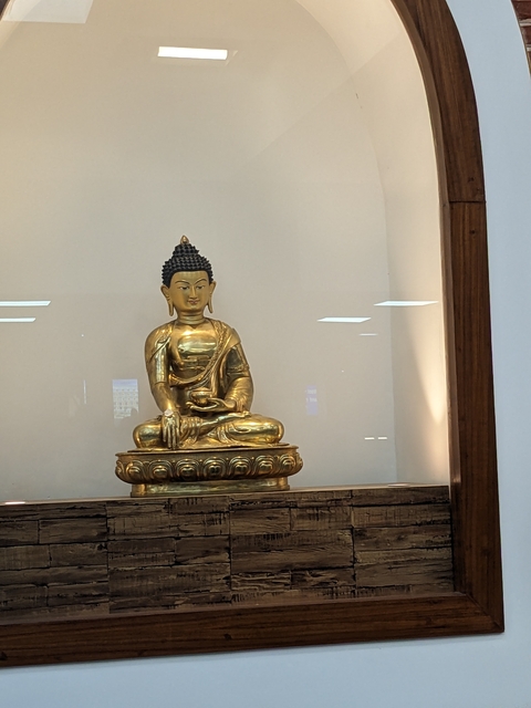 Close-up of a golden Buddha statue in a display.