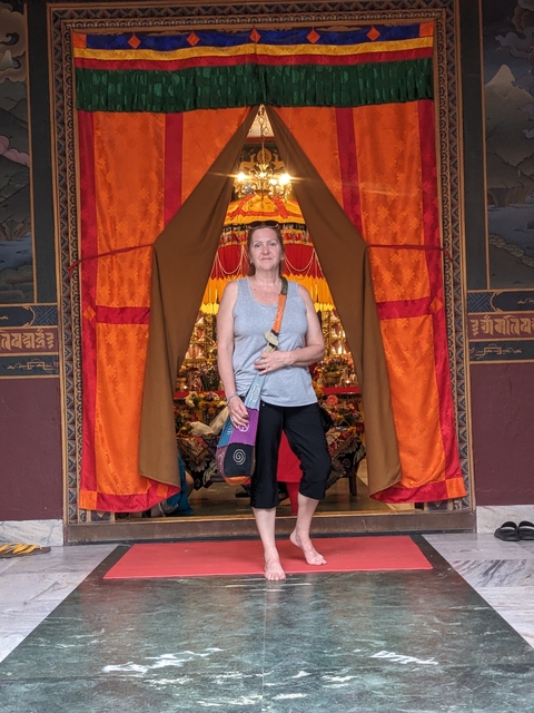       Woman posing in front of a ceremonial altar.
  