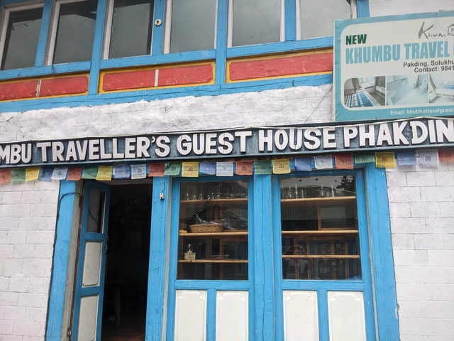       Exterior of Khumbu Traveller's Guest House with prayer flags.
  
