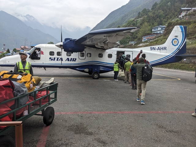       People boarding a small aircraft on the tarmac.
  