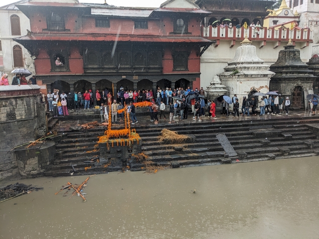       People gathered at an ancient temple during rain.
  