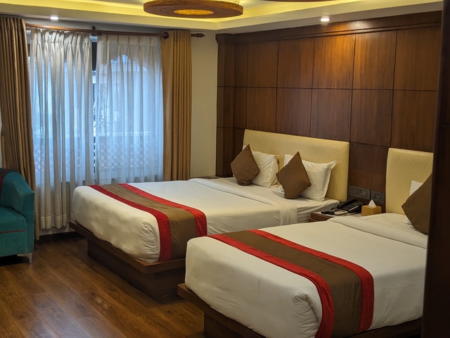 Cozy hotel room with two beds and curtains drawn.