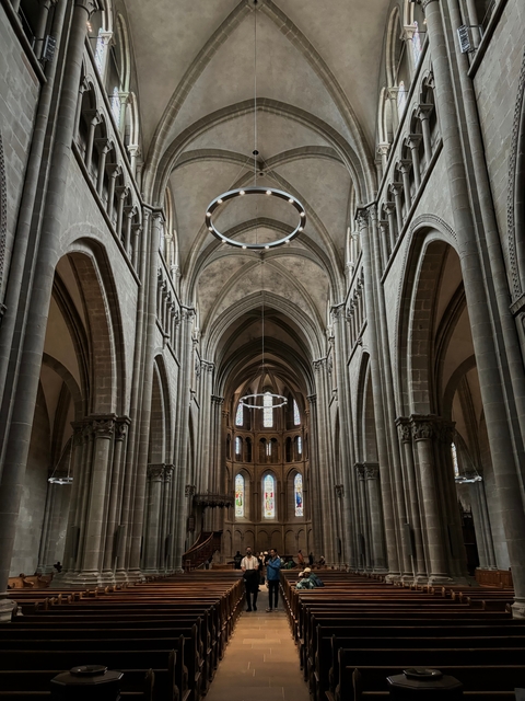 Interior view of a grand cathedral with arches and chandeliers.