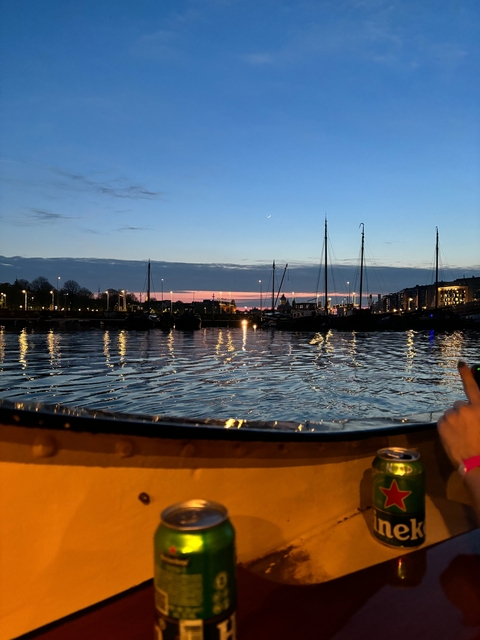      Scenic view of a waterfront with sailing boats at sunset.
  