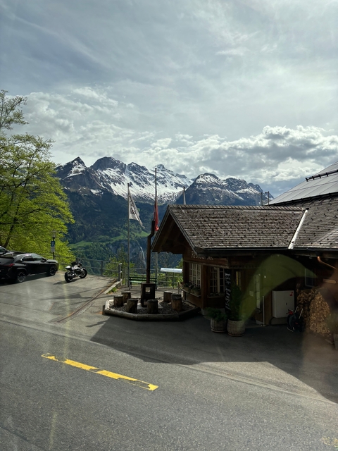 Mountain scene with a lodge, flags, and a motorcycle.