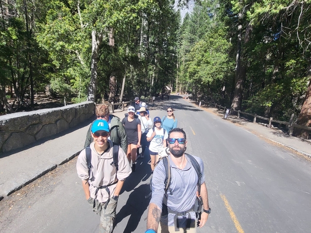 Group of hikers smiling on a forest trail.