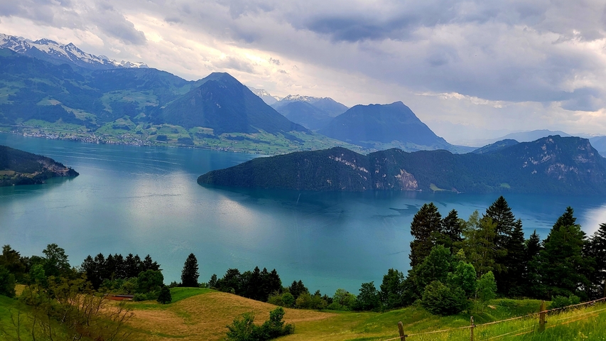 Panoramic view of mountains and a lake with villages.